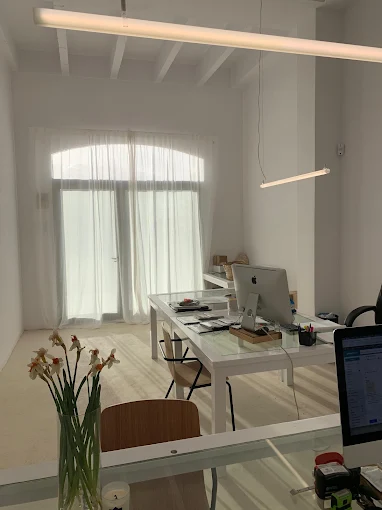 Interior luminoso del estudio con techos altos y mesa de trabajo
